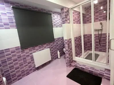 a tiled bathroom with a large tv on the wall at Apartamentos El Olivo in Valencia