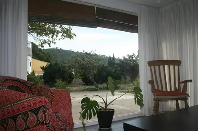 a living room with a couch and a chair and a window at El Campillo, casa de campo cerca de la playa in Navajas
