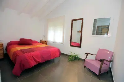 a bedroom with a bed and a mirror and a chair at El Campillo, casa de campo cerca de la playa in Navajas