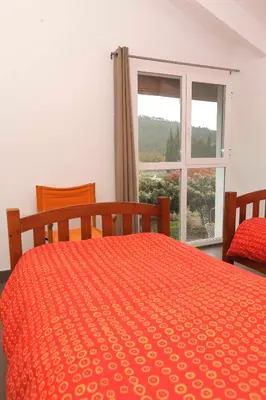 a bedroom with a orange bed with a window at El Campillo, casa de campo cerca de la playa in Navajas