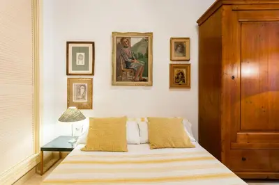 a bedroom with a bed and a table and pictures on the wall at My Loft 4 You Borgia in Valencia