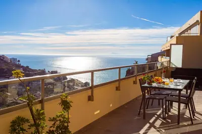 a balcony with a table and chairs and the ocean at Cap Blanc Penthouse Cullera in Faro de Cullera