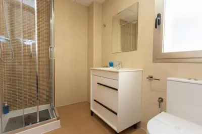 a bathroom with a shower and a sink and a toilet at Cap Blanc Penthouse Cullera in Faro de Cullera
