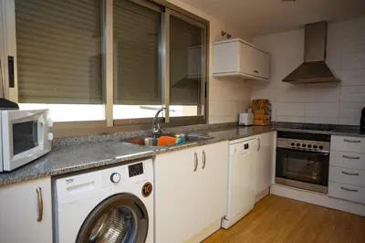 a kitchen with a sink and a washing machine at Cap Blanc Penthouse Cullera in Faro de Cullera