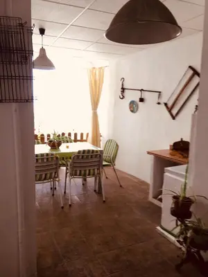 a dining room with a green table and chairs at La casita Santa Bárbara in Macastre