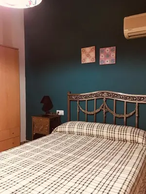 a bedroom with a bed and a blue wall at La casita Santa Bárbara in Macastre