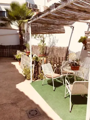 a patio with a table and chairs on a green rug at La casita Santa Bárbara in Macastre