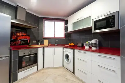 a kitchen with white cabinets and a washer and dryer at My Penthouse Valencia in Valencia