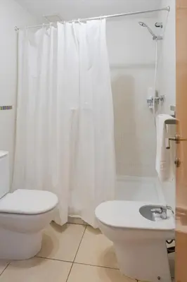 a bathroom with a toilet and a white shower curtain at Quart Silence in Valencia