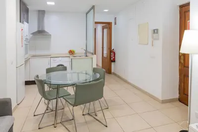 a kitchen with a glass table and green chairs at Quart Silence in Valencia