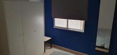 a room with a blue wall and a window at Apartamento Ciudad de las Ciencias in Valencia