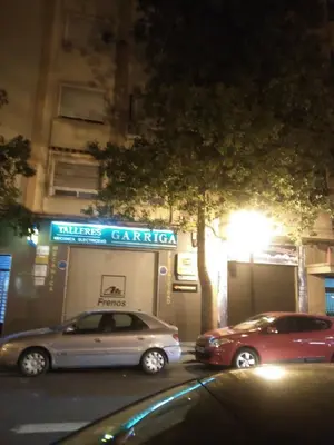 two cars parked in front of a garage at night at Apartamento Ciudad de las Ciencias in Valencia