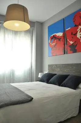 a bedroom with a white bed and a large window at La Casa Verde - Ruzafa in Valencia