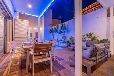 a patio with a table and chairs and a couch at VLVilla - Villa de lujo en Valencia con piscina privada y sala de cine in Burjasot
