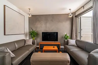 a living room with a couch and a tv at VLVilla - Villa de lujo en Valencia con piscina privada y sala de cine in Burjasot