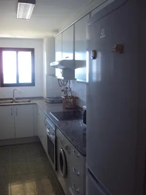 a kitchen with a refrigerator and a washer and dryer at Mirant el Mar in Port Saplaya