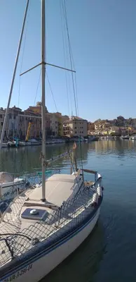a sailboat is docked in a body of water at Mirant el Mar in Port Saplaya