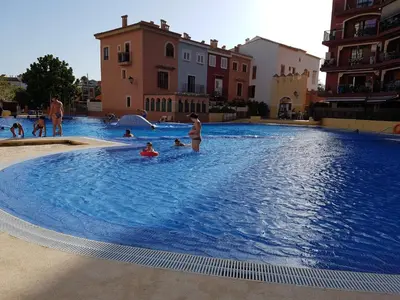a group of people swimming in a large swimming pool at Mirant el Mar in Port Saplaya
