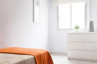 a white room with a bed and a window at Apartamento Cardenal in Valencia