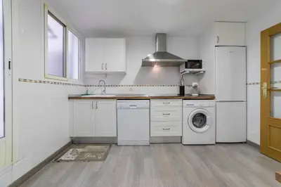 a kitchen with white cabinets and a washer and dryer at Piso Carolina in Valencia