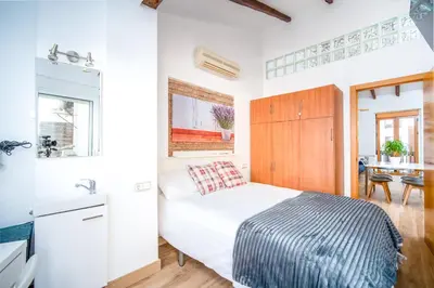 a small bedroom with a bed and a sink at Atico Ruzafa Valencia centro in Valencia