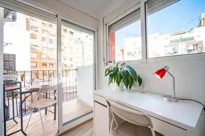 a kitchen with a desk with a lamp and a balcony at Atico Ruzafa Valencia centro in Valencia