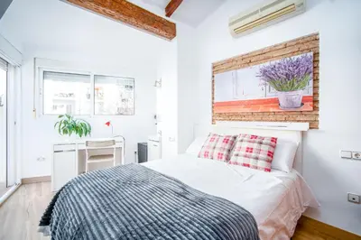 a white bedroom with a bed and a window at Atico Ruzafa Valencia centro in Valencia
