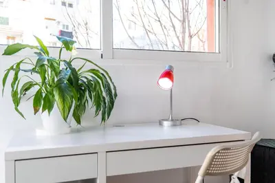 a desk with a lamp and a plant on it at Atico Ruzafa Valencia centro in Valencia
