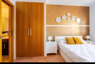 a bedroom with a white bed and a wooden wall at Apartamento con Vista al Mar in Tavernes de Valldigna
