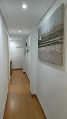a hallway with white walls and a painting on a wall at Céntrico apartamento en Valencia próximo parada de metro Ángel Guimerà in Valencia