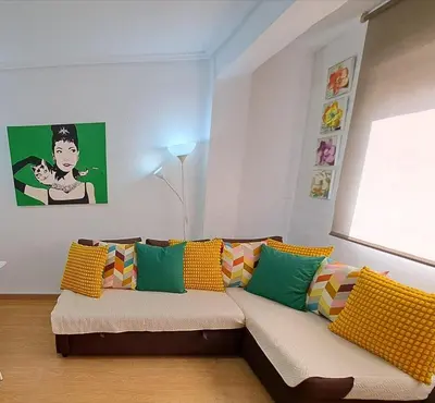 a living room with a couch with colorful pillows at Céntrico apartamento en Valencia próximo parada de metro Ángel Guimerà in Valencia