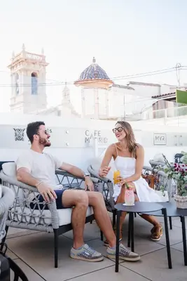 a man and a woman sitting in chairs on a patio at MYR Marqués House in Valencia