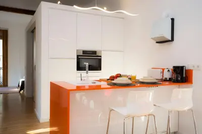 a kitchen with an orange counter and white cabinets at Balcón de Manet in Valencia