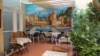 a room with tables and chairs and a painting on the wall at B&B 