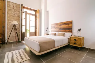 a bedroom with a large bed with a wooden headboard at Barracart Apartments in Valencia