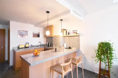 a kitchen with a sink and a counter with stools at Barracart Apartments in Valencia
