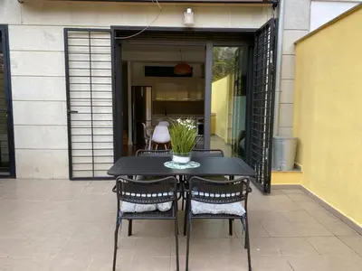 a black table with chairs and a vase of flowers at La casita de Palomar - PalomarGroup in Valencia