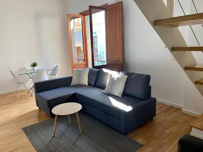 a blue couch in a living room with a table at La casita de Palomar - PalomarGroup in Valencia