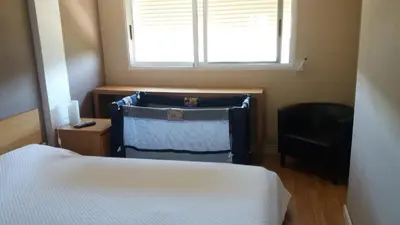a bedroom with a bed and a window and a chair at Piso Playa Patacona/Malvarrosa in Valencia