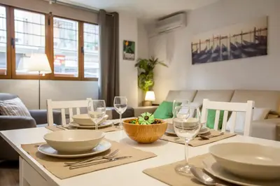 a dining room with a table with plates and wine glasses at Apartamento Alta in Valencia