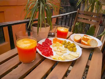 a table with a plate of food and two glasses of juice at Sun Studio Valencia in Valencia