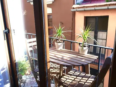 a balcony with a wooden table and potted plants at Sun Studio Valencia in Valencia