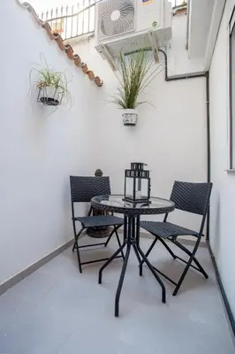 a table and chairs on a balcony with plants at Apartamento Fos in Valencia