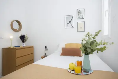a bedroom with a bed with a vase of flowers and drinks at SingularStays Ático Roger de Flor in Valencia