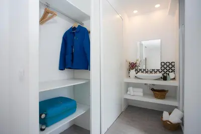 a walk in closet with a blue jacket and a mirror at SingularStays Ático Roger de Flor in Valencia