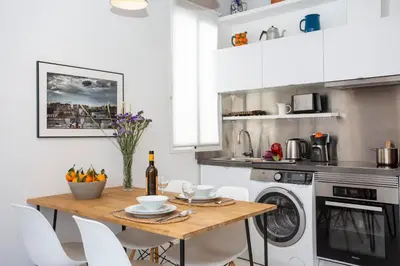 a kitchen with a wooden table and white appliances at SingularStays Ático Roger de Flor in Valencia