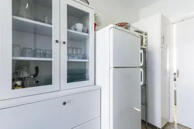 a white kitchen with a white refrigerator at Abaco in Playa de Xeraco