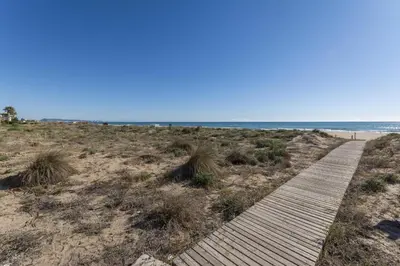 a boardwalk on a beach with the ocean in the background at Abaco in Playa de Xeraco