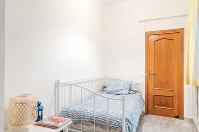 a white bedroom with a bed and a wooden door at Cisneros flat in Valencia