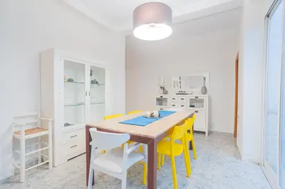 a dining room with a wooden table and yellow chairs at Cisneros flat in Valencia